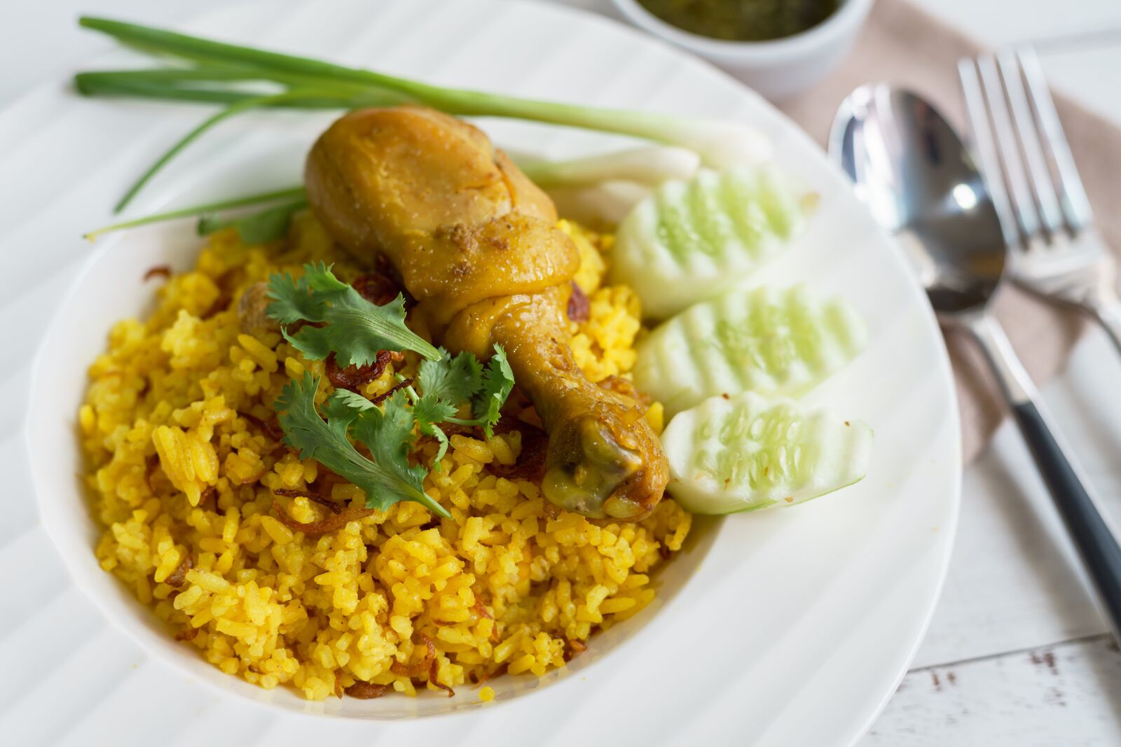Chicken biryani with yellow rice and cucumbers