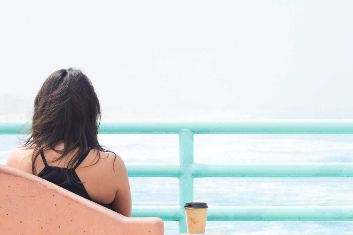 Woman drinking coffee at the beach