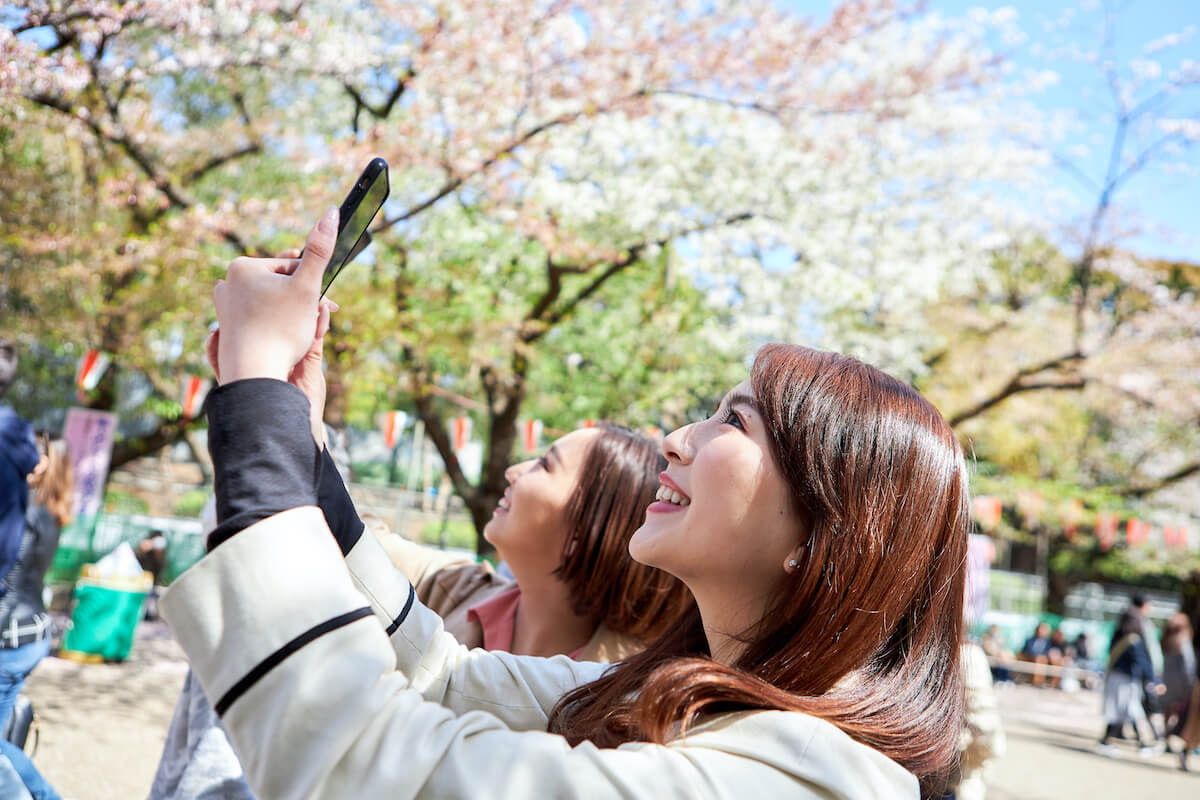 Two women taking selfies during sakura in Japan